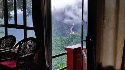 a window with two chairs and a view of a mountain at Valley View Avenue in Meppādi