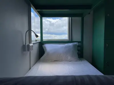a bed in a small room with a window at ABODE Backpacker's Hostel in Madikeri