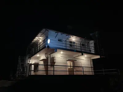 a house lit up at night with lights on it at ABODE Backpacker's Hostel in Madikeri