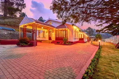 a house with a brick driveway in front of it at Vintage Inglenook Premium Heritage Bungalow Ooty by VOYE HOMES - A Quiet Retreat Close to Ooty Town in Ooty