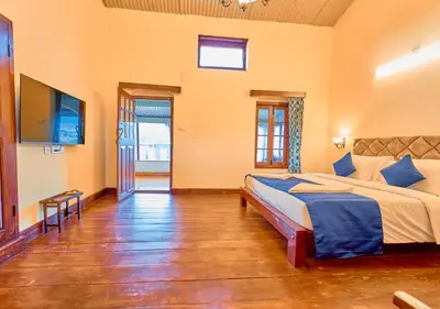 a bedroom with a bed and a flat screen tv at Vintage Inglenook Premium Heritage Bungalow Ooty by VOYE HOMES - A Quiet Retreat Close to Ooty Town in Ooty