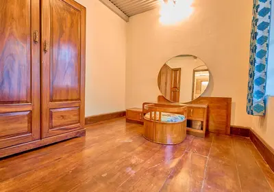 a dressing room with a mirror and a wooden cabinet at Vintage Inglenook Premium Heritage Bungalow Ooty by VOYE HOMES - A Quiet Retreat Close to Ooty Town in Ooty