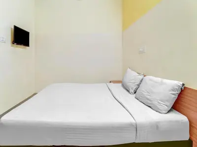 a white bed with two pillows in a room at Sri Balaji castle in Coimbatore