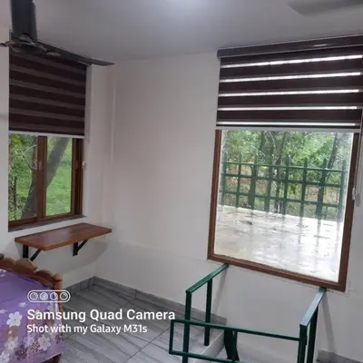 two windows in a room with a table and a window at Farm stay in a coffee plantation near Athirappally in Kodali
