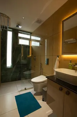 a bathroom with a sink and a toilet and a shower at Ocean Whisper- psst! hidden gem in Kaipamangalam