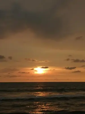 a sunset over the ocean with the sun setting at Ocean Whisper- psst! hidden gem in Kaipamangalam