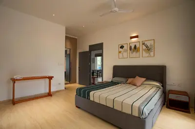 a bedroom with a bed and a table in it at Ocean Whisper- psst! hidden gem in Kaipamangalam