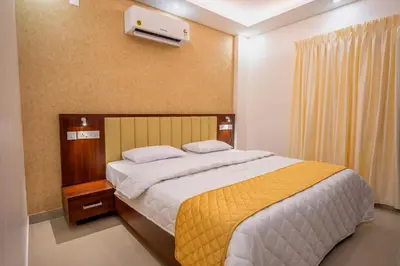 a bedroom with a large bed with a yellow blanket at Metro Residency in Tirūr