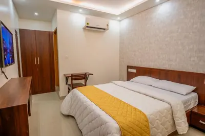 a bedroom with a bed and a television and a table at Metro Residency in Tirūr
