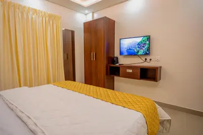 a bedroom with a bed and a flat screen tv at Metro Residency in Tirūr
