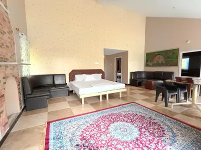 a living room with a bed and a couch and a rug at Mountain View Private Villa in Ooty