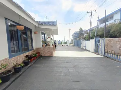 an empty sidewalk next to a building with potted plants at Mountain View Private Villa in Ooty