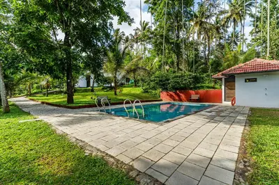 a swimming pool in the backyard of a house at Mahogany by Exuberance Stays in Wayanad