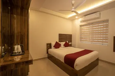 a bedroom with a bed with red pillows and a window at BR Residency in Trichūr