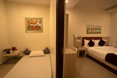 a bedroom with a bed and a small room with a door at BR Residency in Trichūr