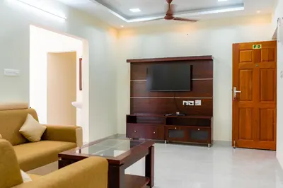 a living room with a couch and a tv at Thapovan coimbatore in Coimbatore