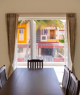 a table and chairs in front of a large window at Thapovan coimbatore in Coimbatore