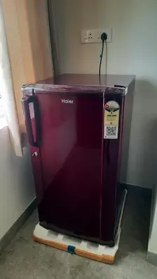 a red refrigerator sitting on a sled in a room at Thapovan coimbatore in Coimbatore