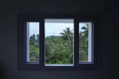 a window with three views of a palm tree at Iyer Square in Attappādi