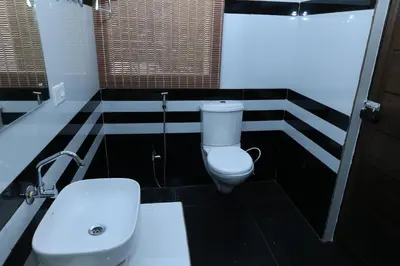 a bathroom with a toilet and a sink at Iyer Square in Attappādi