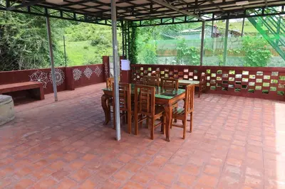 a patio with a table and chairs in a building at Iyer Square in Attappādi