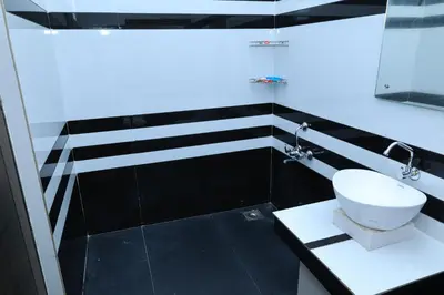 a black and white bathroom with a toilet and a sink at Iyer Square in Attappādi