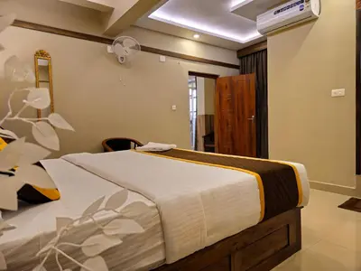 a bedroom with a bed and a ceiling fan at Alicos Residency in Sultan Bathery