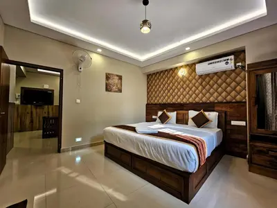 a bedroom with a bed and a television in it at Alicos Residency in Sultan Bathery