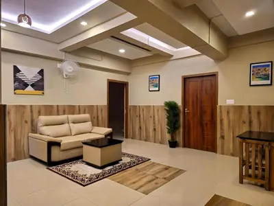 a living room with a couch and a table at Alicos Residency in Sultan Bathery