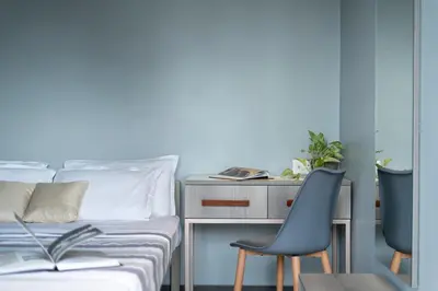 a bedroom with a bed and a desk and a chair at YMCA International Guest House in Trichūr