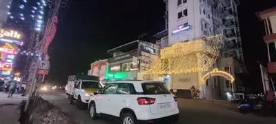 a white car parked on a city street at night at YMCA International Guest House in Trichūr
