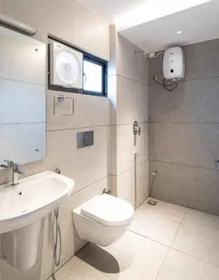 a bathroom with a toilet and a sink at YMCA International Guest House in Trichūr