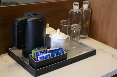 a coffee maker on a tray on a counter at Kowju Airport Hotel Calicut in Kondotti