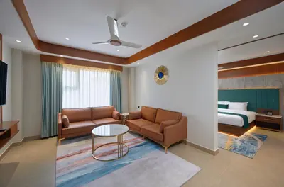 a living room with a couch and a bed at Kowju Airport Hotel Calicut in Kondotti