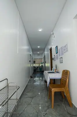 a hallway with a table and a chair in a room at Ganga Homes Rooms Only in Trichūr