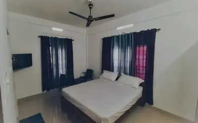 a bedroom with a bed and a ceiling fan at Brighton Retreat in Sultan Bathery