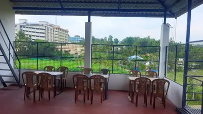 a balcony with a table and chairs and a large window at Brighton Retreat in Sultan Bathery