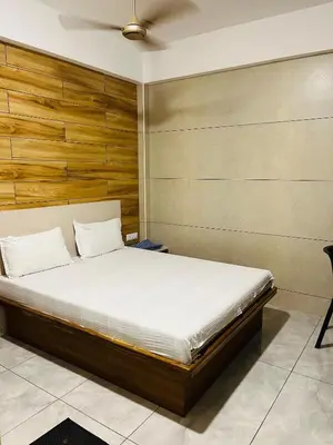 a bedroom with a bed and a wooden wall at Woodland residency in Mettuppālaiyam
