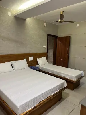 two twin beds in a room with a ceiling at Woodland residency in Mettuppālaiyam