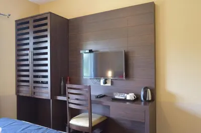 a bedroom with a desk with a chair and a television at Avadale Kodaikanal - Stag Groups Not Allowed in Kodaikānāl