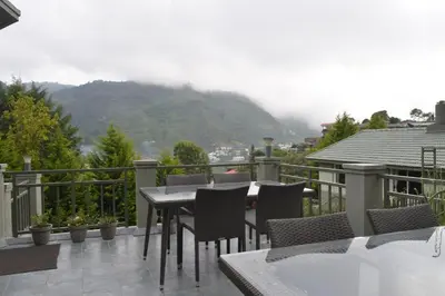 a patio with a table and chairs on a balcony at Avadale Kodaikanal - Stag Groups Not Allowed in Kodaikānāl