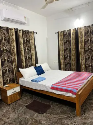 a bedroom with a bed with a curtain and a bed sidx sidx sidx at Montage Villa in Kozhikode