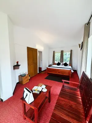 a room with a bed and a table and chairs at Earth songs by Green leaves - 10 kms from kotagiri in Kotagiri