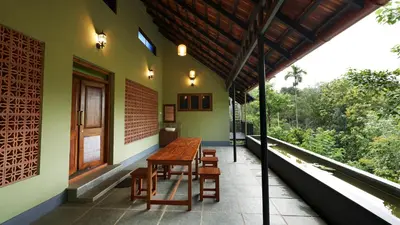 a wooden table on the side of a house at Silvertrails in Kalpetta