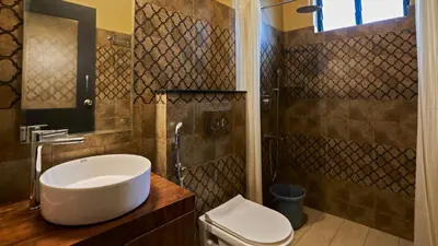 a bathroom with a sink and a toilet and a shower at Silvertrails in Kalpetta