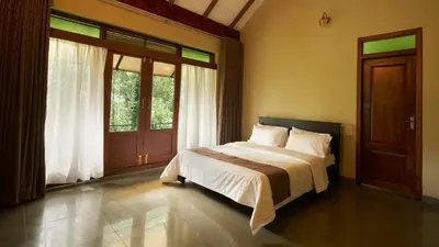 a bedroom with a bed and a large window at Silvertrails in Kalpetta