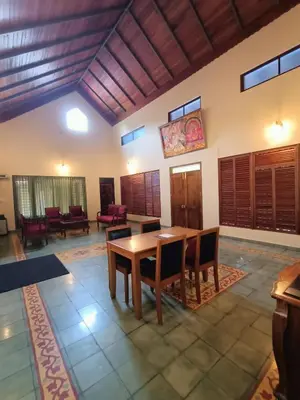 a living room with a wooden table and chairs at Silvertrails in Kalpetta