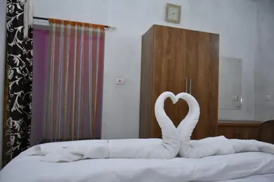 two white swans making a heart on a bed at Dream inn family homestay in Meenangadi