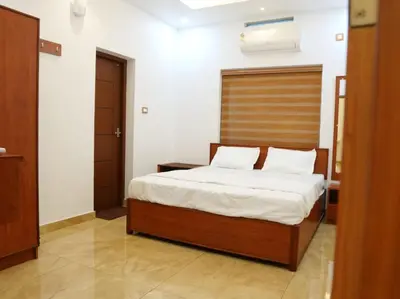 a bedroom with a bed with a wooden headboard at Neom's Golden Gate in Alwaye