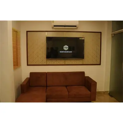 a living room with a couch and a flat screen tv at Neom's Golden Gate in Alwaye